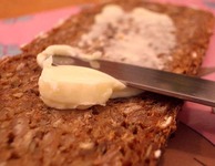 Messer streicht Butter auf ein Brot