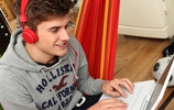 Junger Mann mit Kopfhörern sitzt am Laptop. (Bild: VZ NRW)