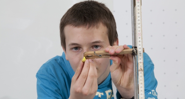 Felix demonstriert einen Versuchsaufbau zur Fallhöhenmessung von Knallerbsen. (Bild: Stiftung Warentest)