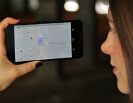 Eine junge Frau hält sich in einem dunklen Tunnel ein Smartphone mit Google Maps vors Gesicht. Bild: Verbraucherzentrale NRW