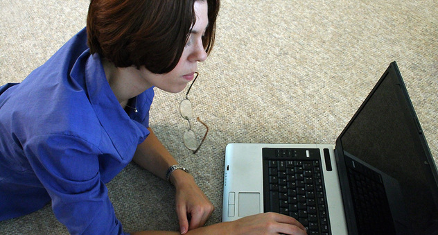 Junge Frau auf dem Boden liegend am Laptop (Bild: sxc.hu / channah)