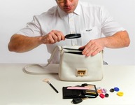 Detektiv durchsucht eine Handtasche (Bild: Dron / fotolia.com)