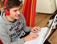 Junger Mann mit Kopfhörern sitzt am Laptop. (Bild: VZ NRW)