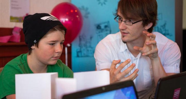 Jugendlicher und Mann sitzen am Computer und diskutieren. (Bild: Philipp Baumgarten)
