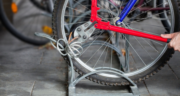 Ein Mann schneidet mit einem Bolzenschneider ein Fahrradschloss am Fahrradständer durch. (Bild: eyetronic / Fotolia)