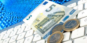 Ein 5-Euro-Schein und Münzen liegen auf einer Tastatur als Symbol für Online-Shopping. Bild: v.poth / Fotolia.com
