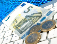 Ein 5-Euro-Schein und Münzen liegen auf einer Tastatur als Symbol für Online-Shopping. Bild: v.poth / Fotolia.com