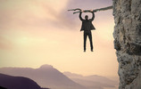 Mann hängt über einem Abgrund an einem Ast (Bild: alphaspirit / fotolia.com)
