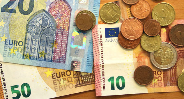 Geldscheine (50, 20 und 10 Euro) und diverse Euro-Münzen liegen auf einem Tisch. Foto: Checked4you
