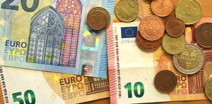 Geldscheine (50, 20 und 10 Euro) und diverse Euro-Münzen liegen auf einem Tisch. Foto: Checked4you