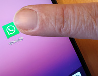 Finger tippt auf Smartphone-Display mit WhatsApp-Symbol. (Bild: Verbraucherzentrale NRW)