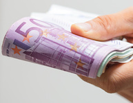 Hand hält gefaltetes Bündel mit Euro-Geldscheinen. Bild: vege / Fotolia