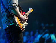 Konzertmusiker mit Gitarre auf einer Bühne, im Hintergrund Publikum. Foto: Pexels/Pixabay.com